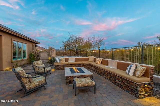 patio terrace at dusk featuring an outdoor living space with a fire pit