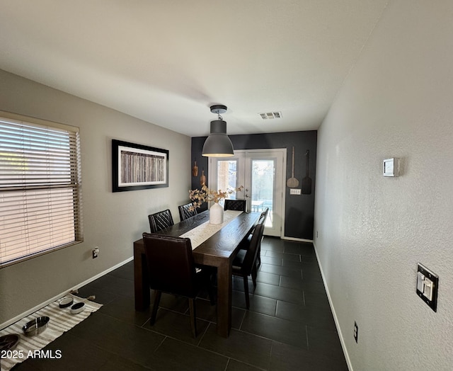 tiled dining area featuring french doors