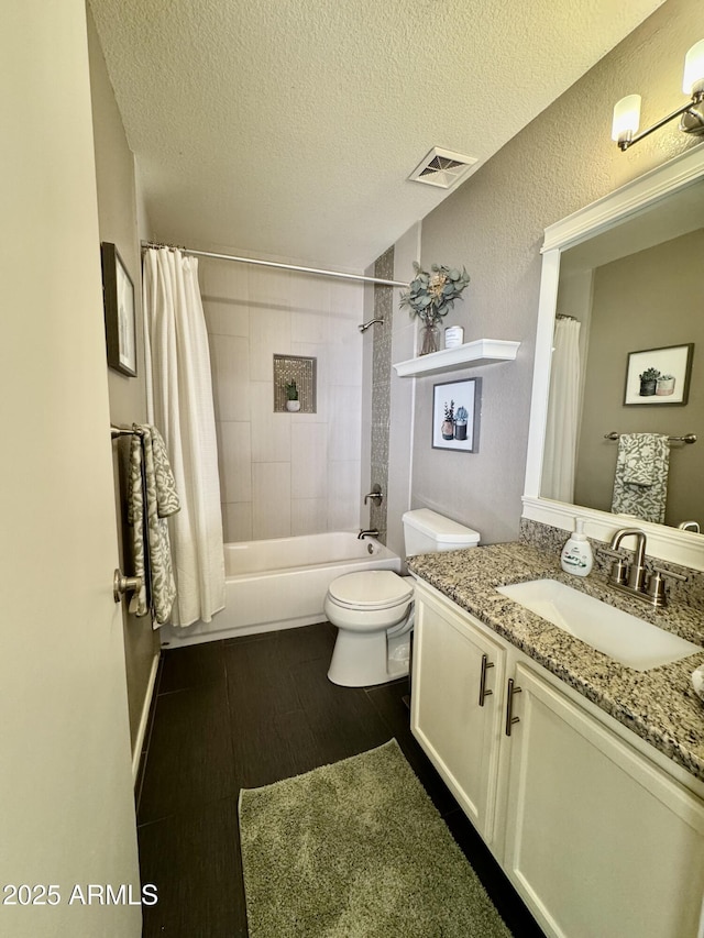 full bathroom with shower / tub combo with curtain, hardwood / wood-style floors, vanity, a textured ceiling, and toilet