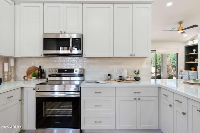 kitchen featuring decorative backsplash, white cabinets, appliances with stainless steel finishes, and light countertops