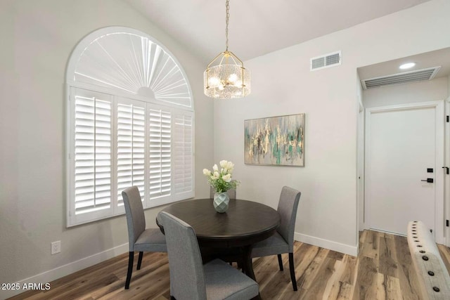 dining room with wood finished floors, visible vents, and baseboards