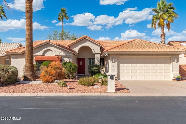 mediterranean / spanish home featuring a tile roof, a garage, driveway, and stucco siding