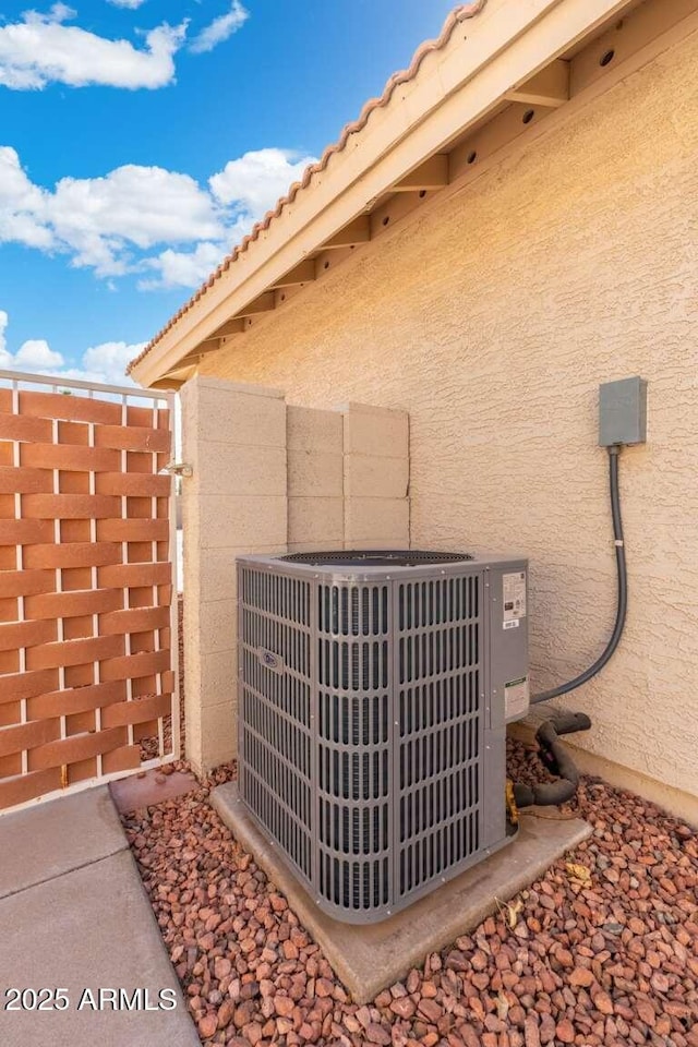 exterior details featuring stucco siding and central AC unit