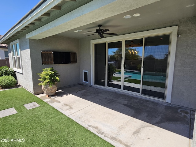 18871 S 209th Way, Queen Creek, AZ 85142 - doorway to property featuring a ceiling fan, a patio, stucco siding, and a yard