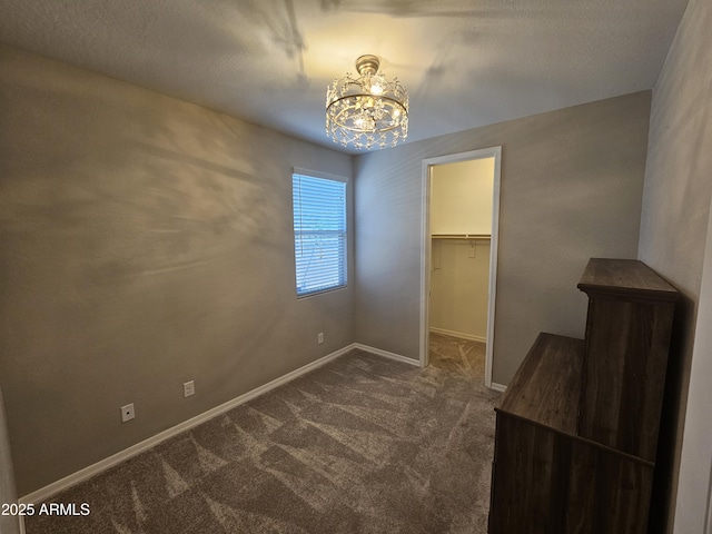 18871 S 209th Way, Queen Creek, AZ 85142 - unfurnished bedroom with a chandelier, dark colored carpet, a walk in closet, and a closet