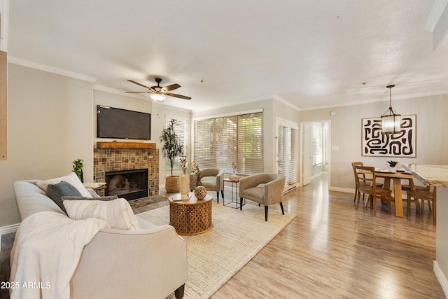 living area with ornamental molding, a brick fireplace, baseboards, and wood finished floors