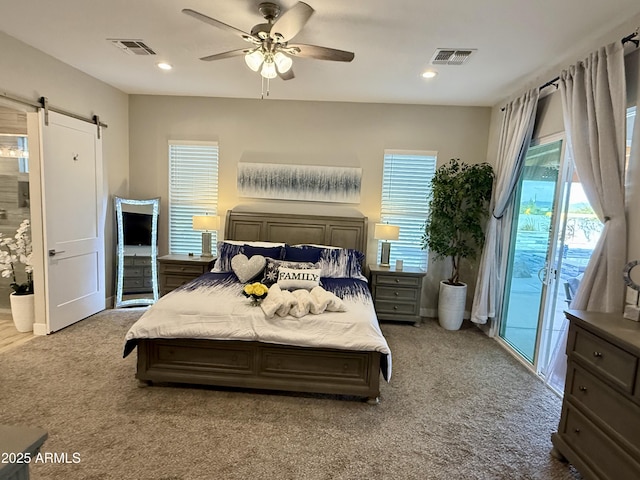 bedroom with access to exterior, visible vents, a barn door, and carpet floors