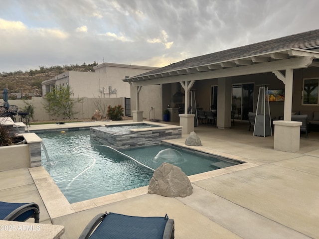 view of swimming pool with fence, a pool with connected hot tub, and a patio area
