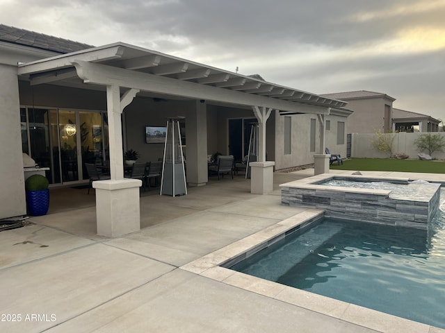 back of house with stucco siding, fence, a fenced in pool, a patio, and an in ground hot tub