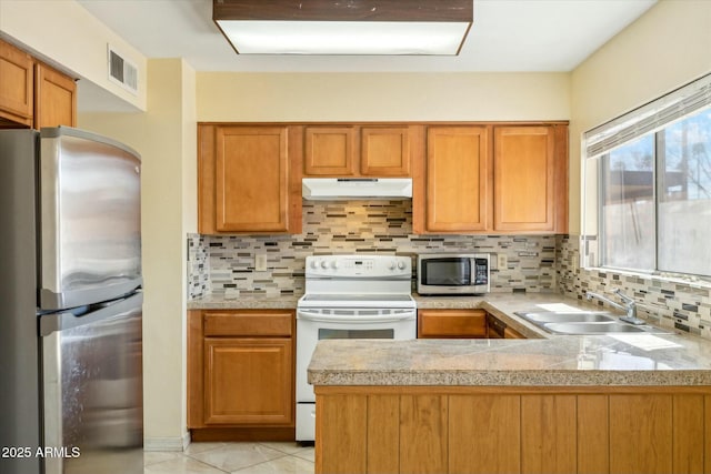 kitchen with tasteful backsplash, visible vents, under cabinet range hood, appliances with stainless steel finishes, and a sink