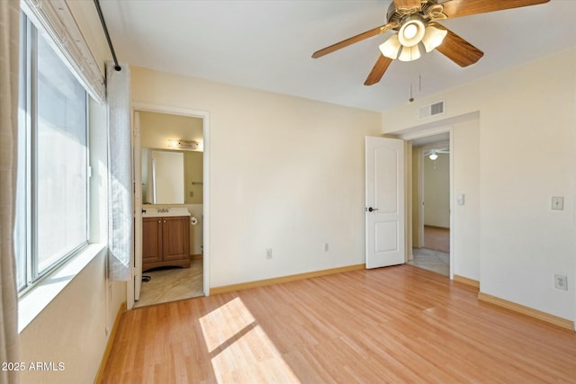 unfurnished bedroom featuring visible vents, multiple windows, baseboards, and light wood-style flooring