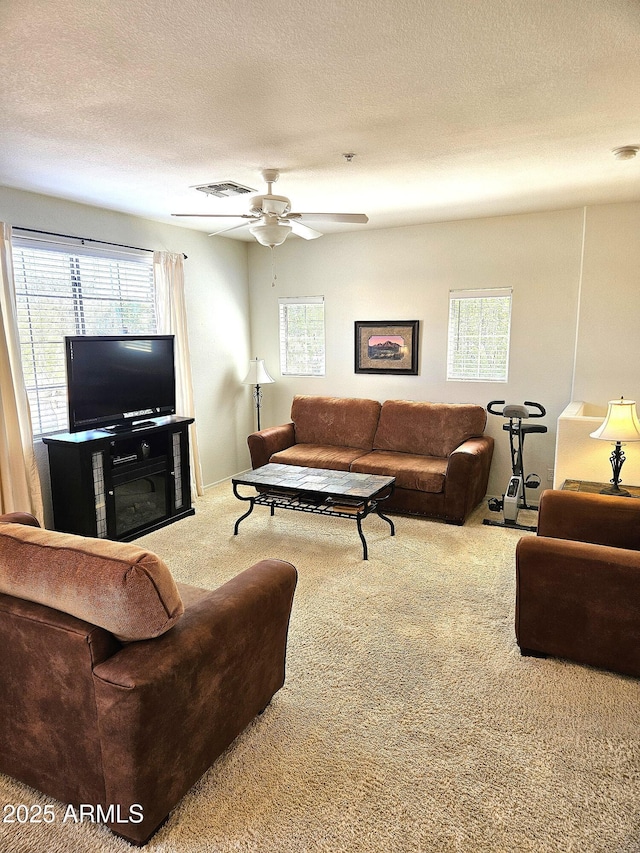 1265 S Aaron Unit 299, Mesa, AZ 85209 - carpeted living room with healthy amount of natural light, ceiling fan, and a textured ceiling
