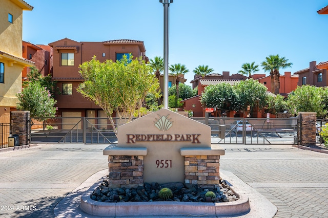 community / neighborhood sign featuring a gate and fence