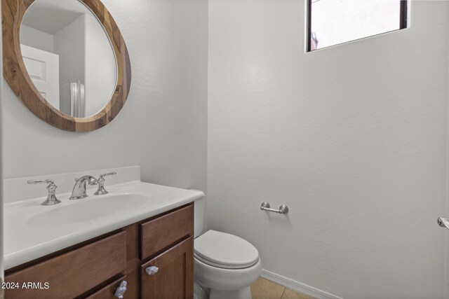 bathroom featuring toilet, tile patterned flooring, baseboards, and vanity