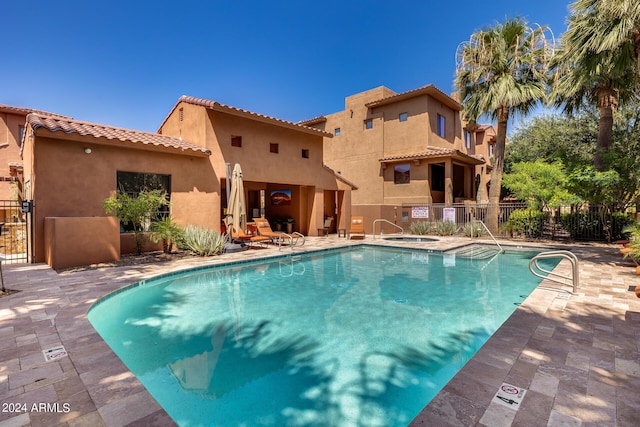 view of swimming pool with a patio and a hot tub