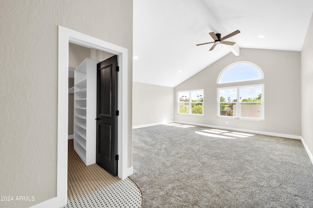 spare room featuring ceiling fan, lofted ceiling with beams, and light carpet