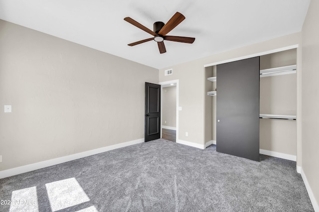 unfurnished bedroom with ceiling fan, a closet, and dark carpet