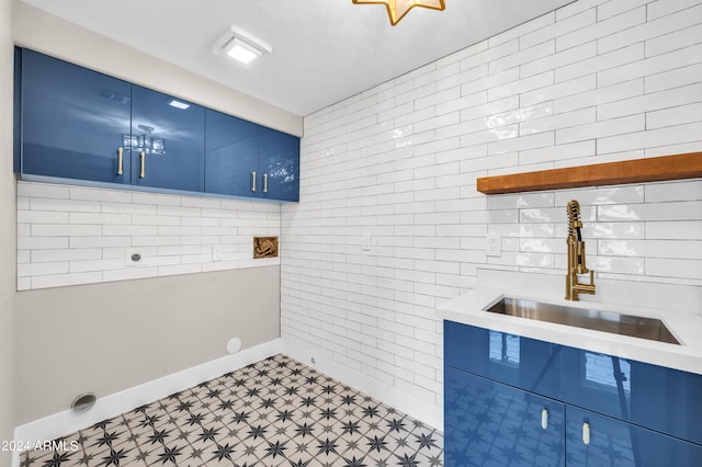 clothes washing area featuring cabinets and sink