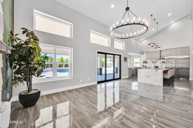 interior space with a notable chandelier, a high ceiling, and light hardwood / wood-style flooring