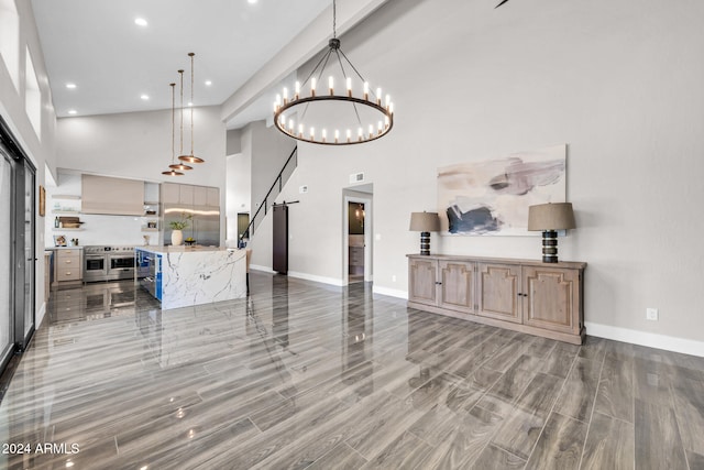 living room featuring a notable chandelier, a towering ceiling, and dark wood-type flooring