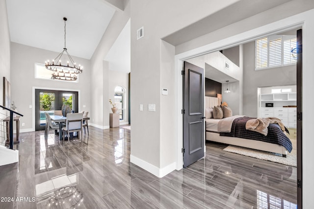 entrance foyer with french doors, wood-type flooring, an inviting chandelier, high vaulted ceiling, and beamed ceiling