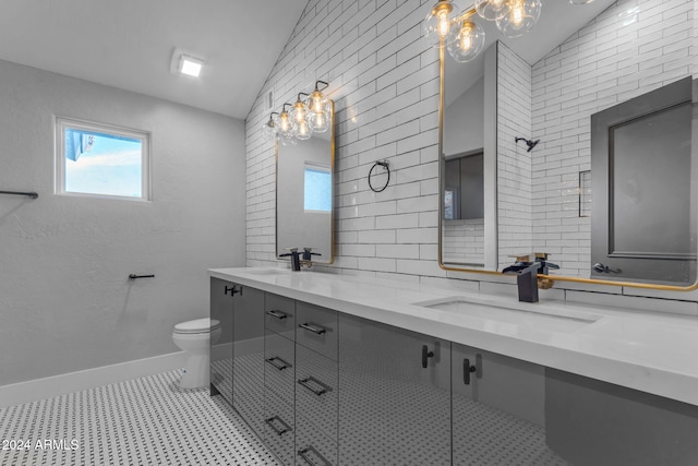 bathroom featuring toilet, tile patterned floors, vanity, and vaulted ceiling