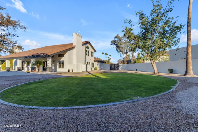 view of side of property featuring a lawn and a patio area