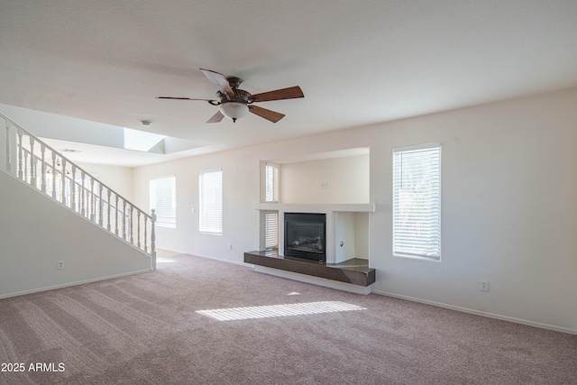 3365 N Sunaire, Mesa, AZ 85215 - unfurnished living room with carpet, a ceiling fan, stairway, baseboards, and a glass covered fireplace