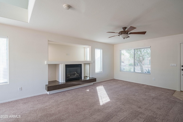3365 N Sunaire, Mesa, AZ 85215 - unfurnished living room featuring carpet flooring, ceiling fan, a glass covered fireplace, and baseboards