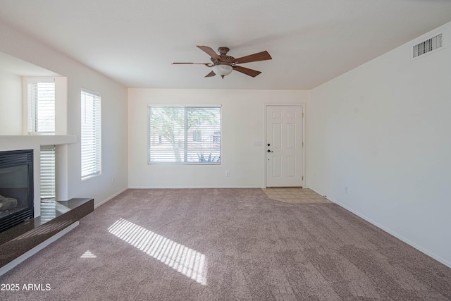 3365 N Sunaire, Mesa, AZ 85215 - unfurnished living room with carpet flooring, a ceiling fan, a glass covered fireplace, and baseboards
