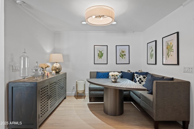 dining area with light wood-style flooring, ornamental molding, baseboards, and breakfast area