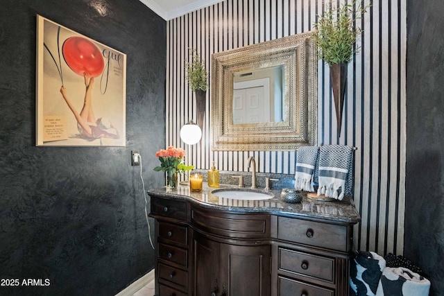 bathroom featuring baseboards, wallpapered walls, vanity, and ornamental molding