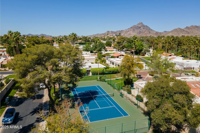 view of tennis court with a mountain view and fence