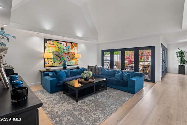 living room with baseboards, high vaulted ceiling, wood finished floors, and french doors