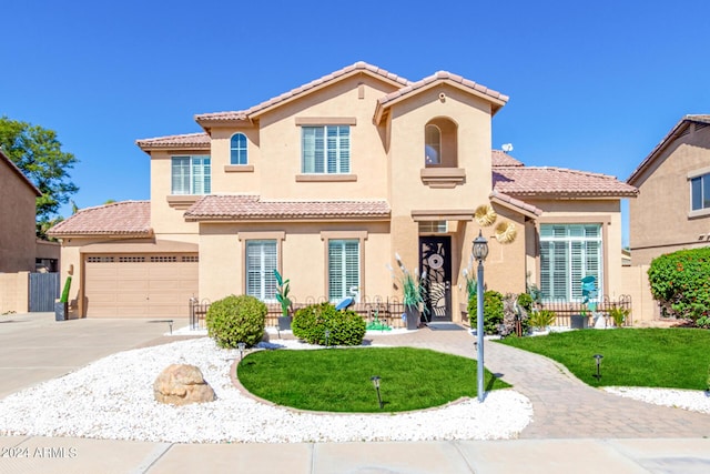 mediterranean / spanish house with a garage and a front lawn