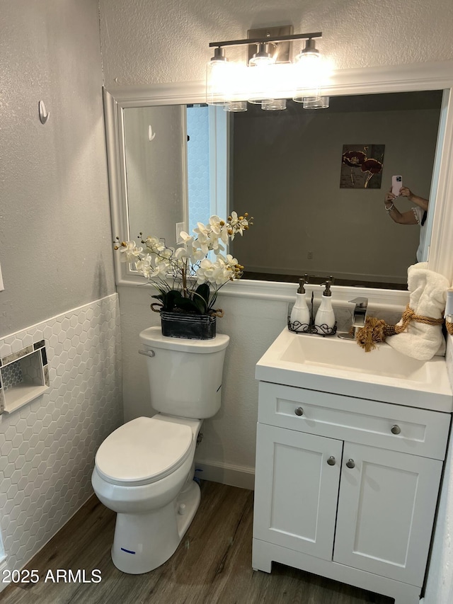 bathroom with wood-type flooring, vanity, and toilet