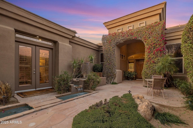 patio terrace at dusk featuring french doors