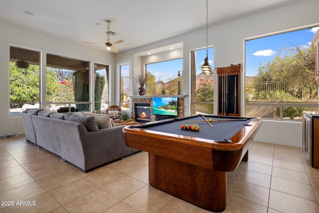 playroom with a wealth of natural light, a glass covered fireplace, and light tile patterned floors