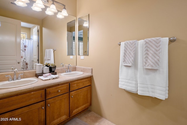 full bath with tile patterned floors, double vanity, and a sink