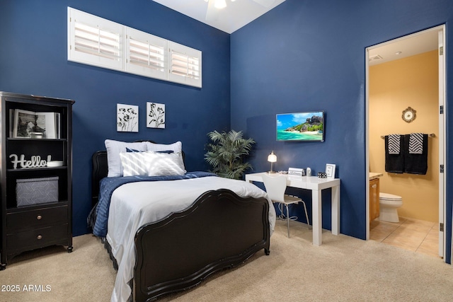 bedroom with tile patterned floors, carpet floors, and connected bathroom