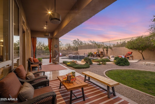 patio terrace at dusk with a fenced in pool, a fenced backyard, and outdoor lounge area