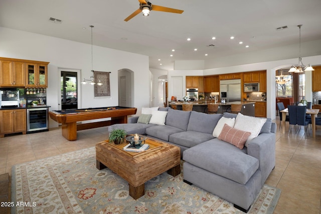 living area featuring beverage cooler, visible vents, a healthy amount of sunlight, and arched walkways