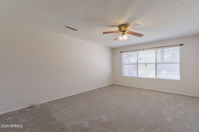 carpeted spare room with ceiling fan and a textured ceiling