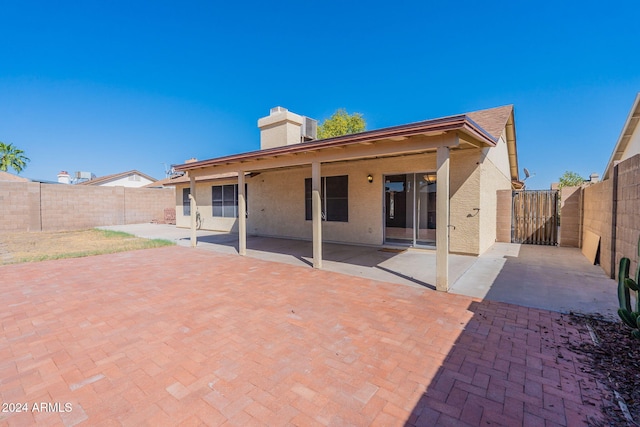 16410 S 46th Pl, Phoenix, AZ 85048 - back of house with a fenced backyard, a gate, stucco siding, and a chimney