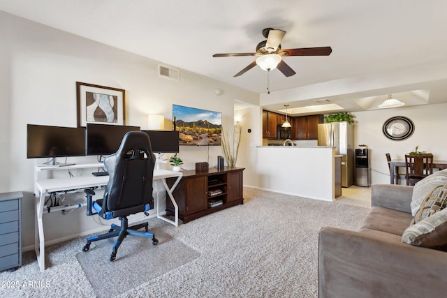 home office featuring light carpet, ceiling fan, and visible vents