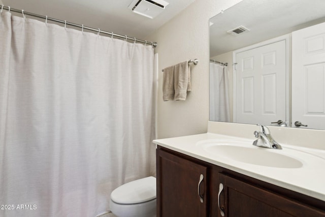 bathroom with visible vents, vanity, and toilet