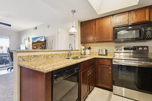 kitchen with visible vents, light stone counters, a peninsula, black appliances, and a sink