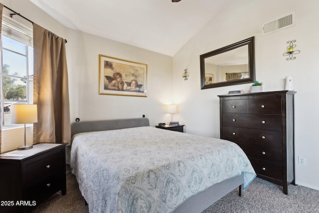 carpeted bedroom with visible vents and vaulted ceiling