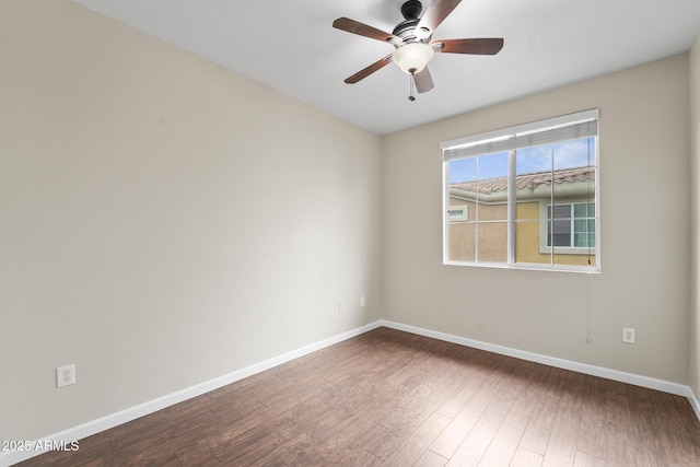 unfurnished room with dark wood-style floors, baseboards, and a ceiling fan