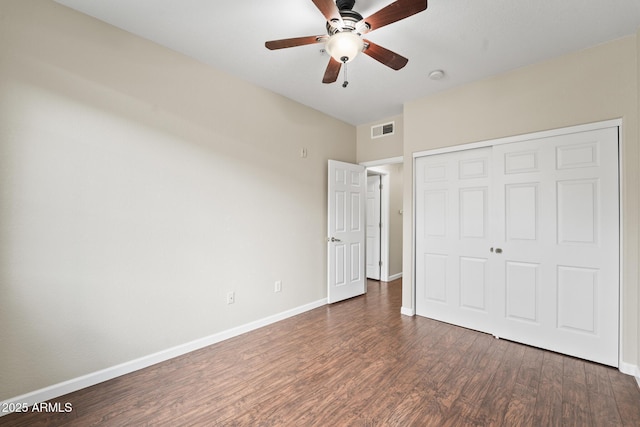 unfurnished bedroom with baseboards, visible vents, ceiling fan, wood finished floors, and a closet